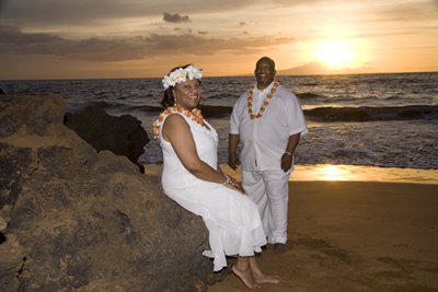 couple taking photos at their sunset hawaii vow renewal