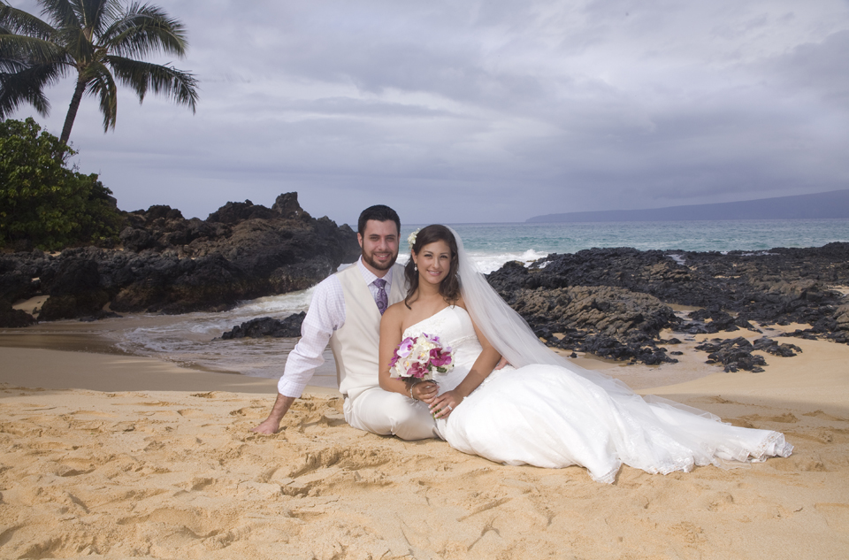 sitting in sand at their Maui Wedding in Hawaii